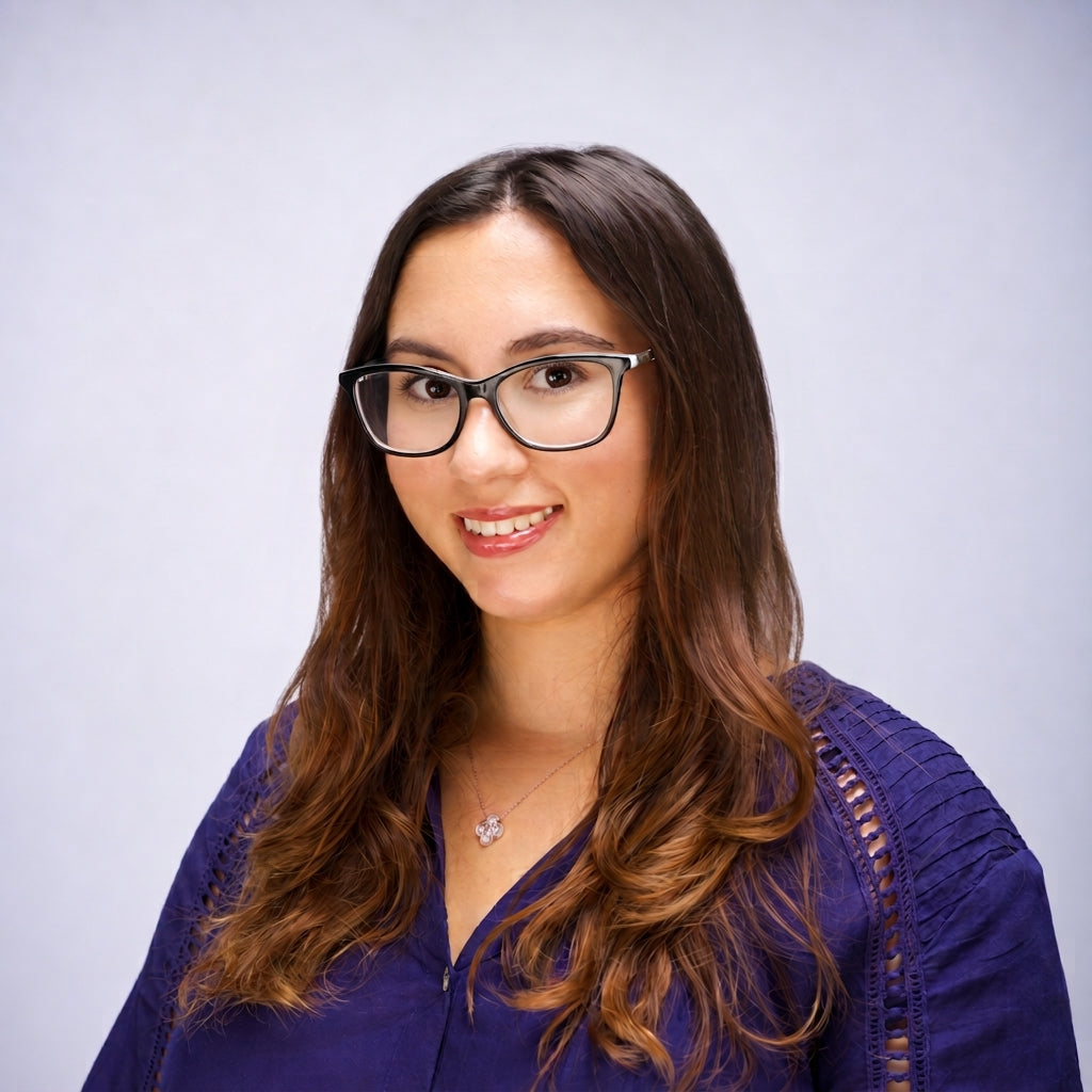Robin Petrogiannis, studio headshot against a pale lilac backdrop.